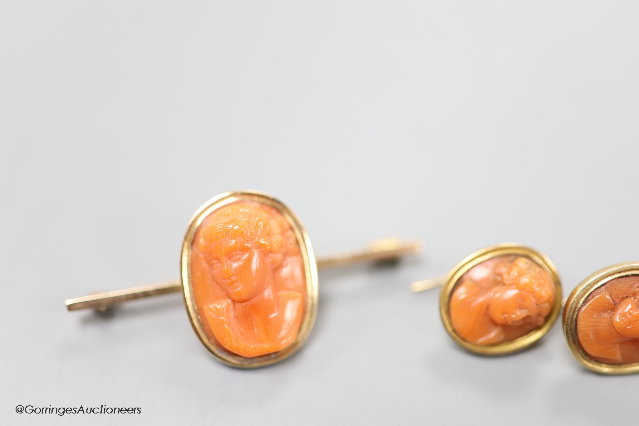 A Victorian carved coral set bar brooch, 45mm and a pair of similar earrings (all adapted), gross weight 12.2 grams.